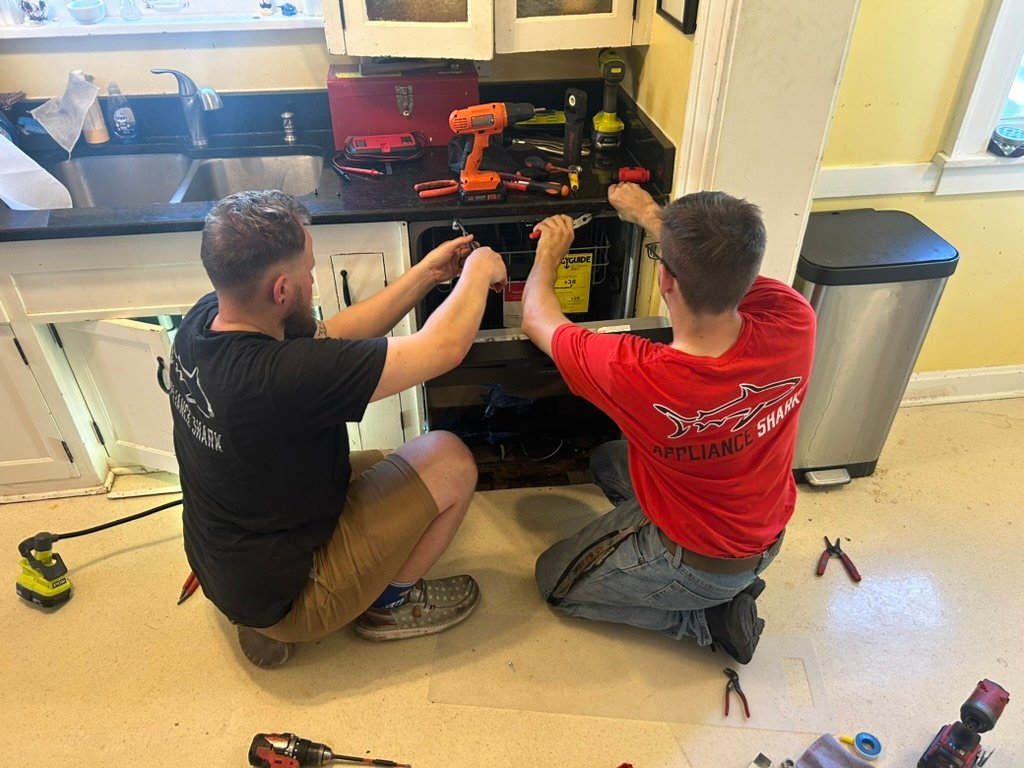 Appliance Shark technicians repairing an appliance in a customer's kitchen